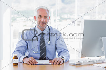 Attractive doctor sitting at his desk