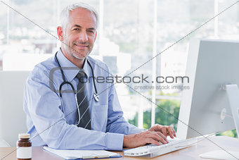 Doctor typing and using his computer