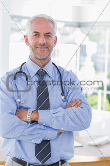 Attractive doctor with his arms crossed