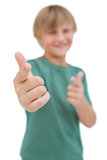 Blonde boy giving thumbs up and pointing