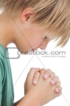 Little boy saying his prayers side view