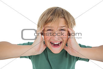 Cute boy shouting and covering his ears