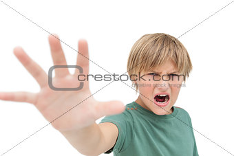 Furious little boy shouting and making stop sign with hand