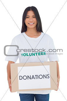 Smiling volunteer holding a donation box