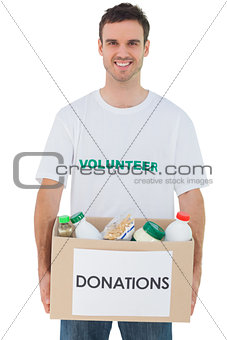Handsome man carrying donation box with food