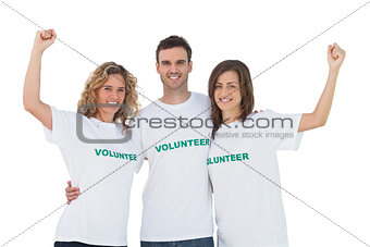 Smiling group of volunteers raising arms