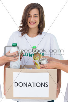 Smiling volunteer holding a food donation box