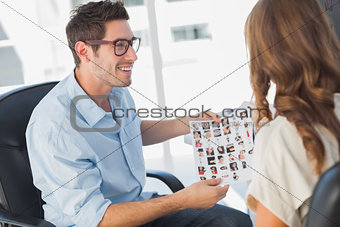 Photo editor showing a contact sheet to a colleague
