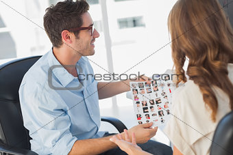Photo editor showing contact sheet to a colleague