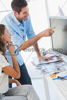 Cheerful photo editors working together on a computer