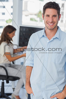 Handsome photo editor standing with hands in pocket