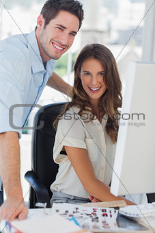 Happy photo editors working together on a computer