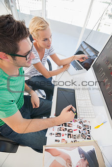 Cheerful photo editors working together on graphics tablet
