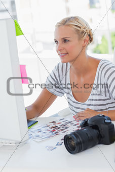 Cheerful photo editor working at her desk