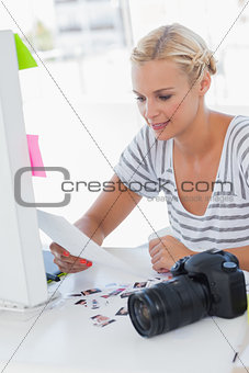 Cheerful photo editor looking at a contact sheet