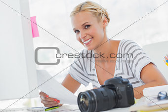 Blonde photo editor holding a contact sheet