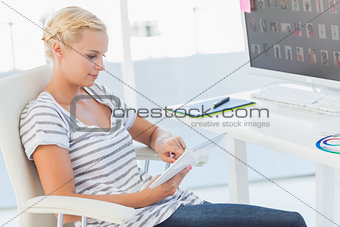 Blonde photo editor working on a tablet computer