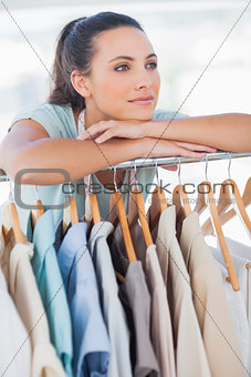Fashion designer leaning on clothes rail
