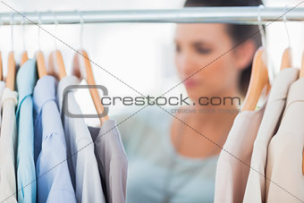 Fashion woman choosing clothes on clothes rail