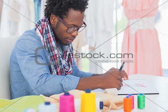Fashion designer sitting at his desk