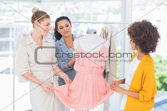 Fashion designers looking at a dress