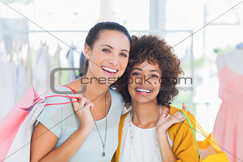 Smiling friends holding shopping bags