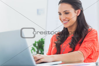 Smiling designer working on her laptop