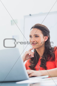 Thoughtful designer sitting behind her desk