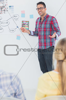 Handsome interior designer pointing at a wall