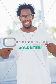 Cheerful man pointing to his volunteer tshirt