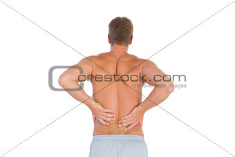 Shirtless man suffering from lower back pain