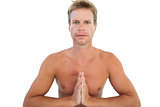 Shirtless man doing yoga and meditating