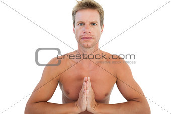 Shirtless man doing yoga and meditating