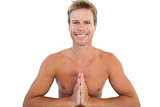 Cheerful man doing yoga and meditating