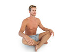 Handsome man doing yoga and sitting in lotus position