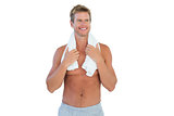 Shirtless man standing with a towel around his neck