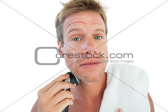 Topless man shaving his beard
