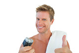 Cheerful man giving thumbs up while holding a razor