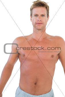 Shirtless man gesturing in front of the camera