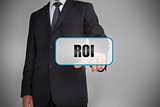 Businessman selecting tag with roi written on it