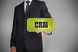 Businessman selecting green tag with the word crm written on it