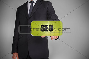 Businessman selecting green tag with the word seo written on it