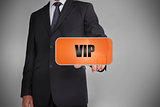 Businessman touching orange tag with the word vip written on it