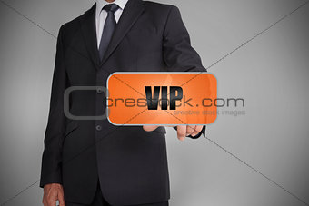 Businessman touching orange tag with the word vip written on it