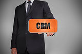Businessman touching orange tag with the word crm written on it