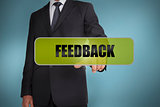 Businessman touching the word feedback written on green tag