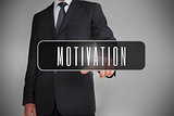 Businessman selecting the word motivation written on black tag