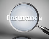 Magnifying glass showing insurance word in white