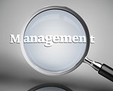 Magnifying glass showing management word in white