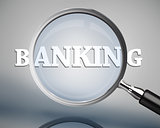 Magnifying glass showing banking word in white